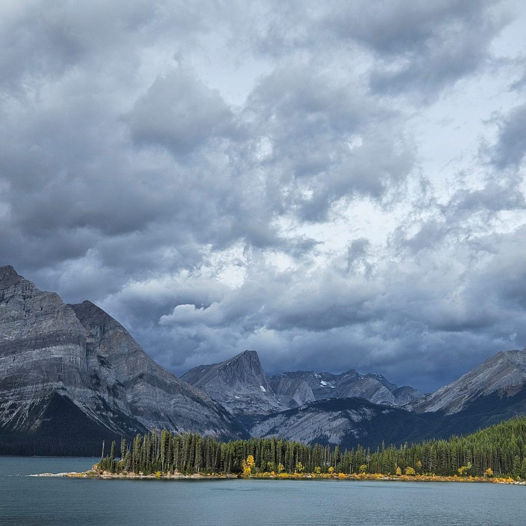 rocky-mountains-grey-clouds-yellow-trees